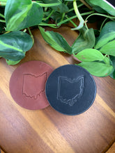Load image into Gallery viewer, circular leather coaster black brown with the state of ohiostamped in the middle
