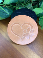 Load image into Gallery viewer, circular leather coaster tan with a heart and paw print stamped in the middle
