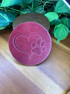 circular leather coaster burgundy with a heart and paw print stamped in the middle