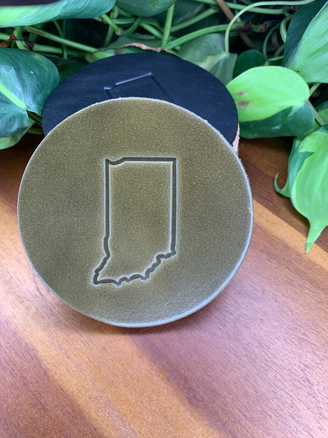 circular leather coaster olive with the state of indiana stamped in the middle