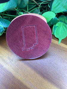 circular leather coaster burgundy with the state of indiana stamped in the middle