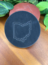 Load image into Gallery viewer, circular leather coaster black with the state of ohio stamped in the middle
